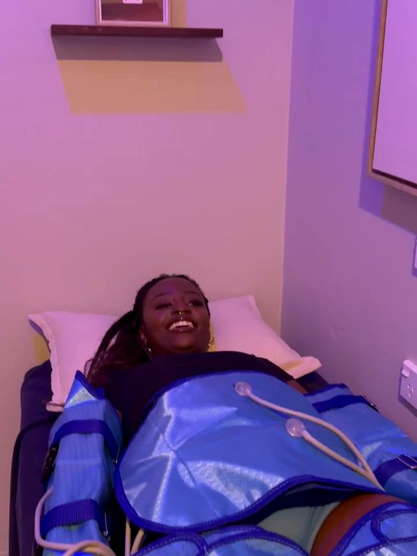 Someone smiling on the treatment bed at Renew in full compression sleeves