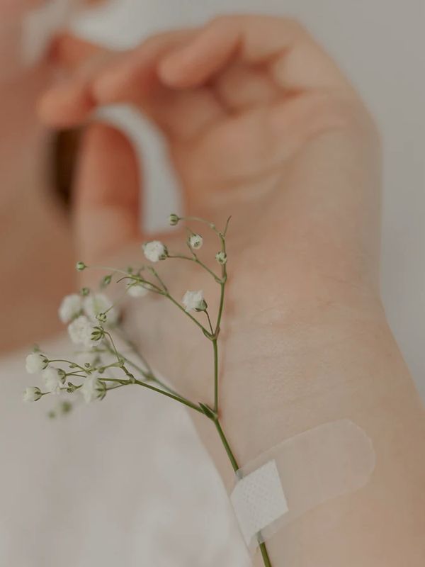 A small plaster on the inside of a forearm after a cannula has been removed