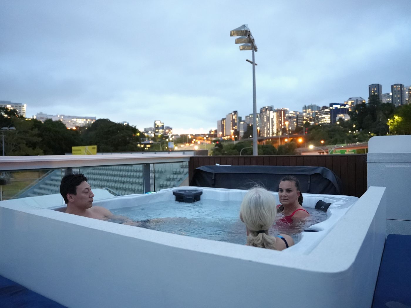 The rooftop spa bath at Renew at dusk, with the Auckland skyline behind it